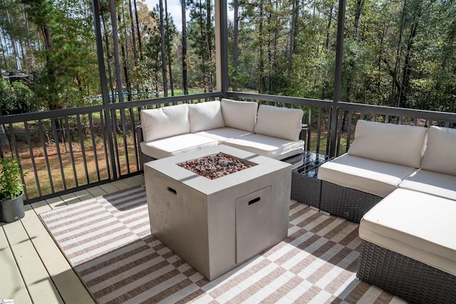 deck with an outdoor living space with a fire pit