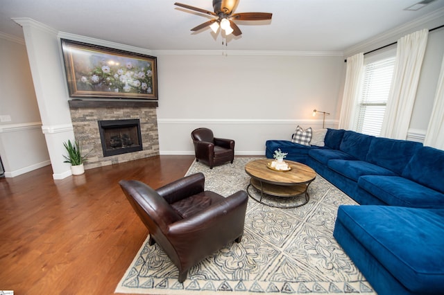 living room with a fireplace, hardwood / wood-style flooring, ceiling fan, and ornamental molding