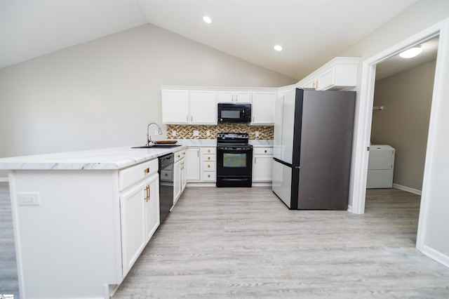 kitchen with white cabinetry, sink, kitchen peninsula, washer / dryer, and black appliances