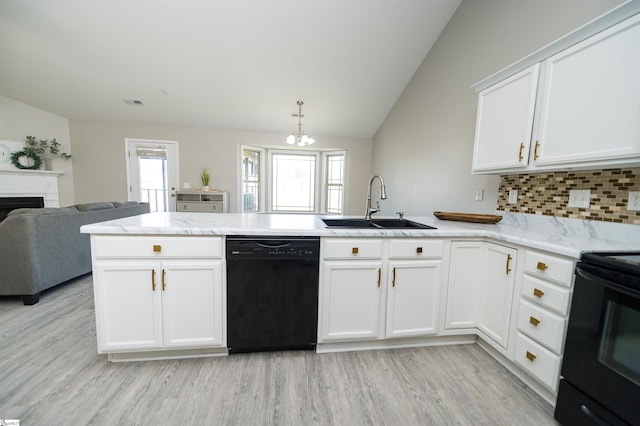 kitchen featuring black appliances, sink, vaulted ceiling, decorative backsplash, and kitchen peninsula