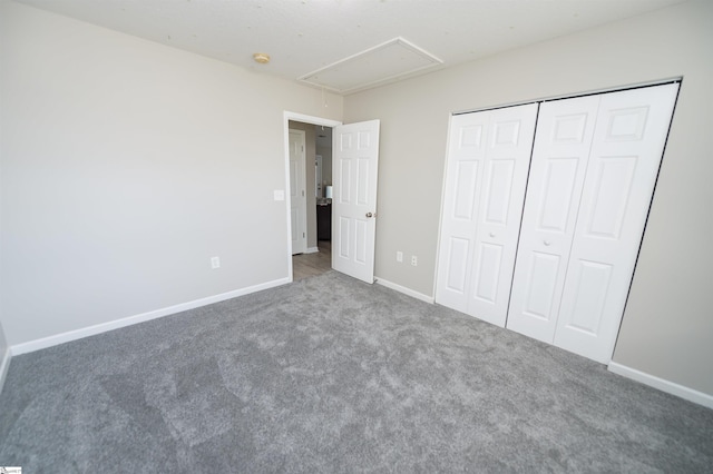 unfurnished bedroom with a closet and dark colored carpet