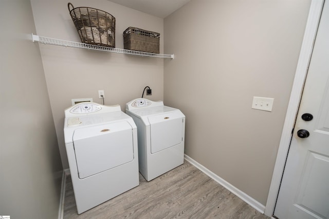 washroom featuring washer and clothes dryer and light wood-type flooring