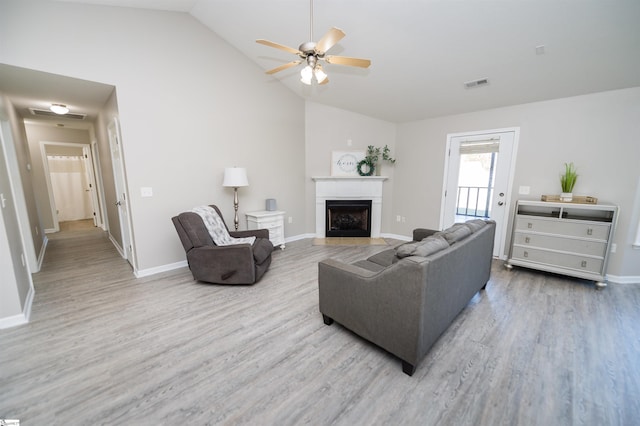 living room featuring ceiling fan, hardwood / wood-style floors, and lofted ceiling