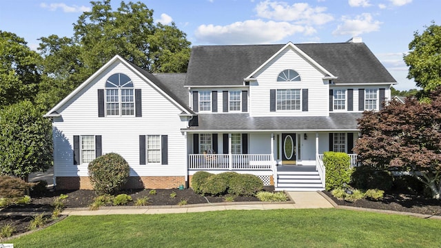 colonial-style house featuring a front lawn and covered porch