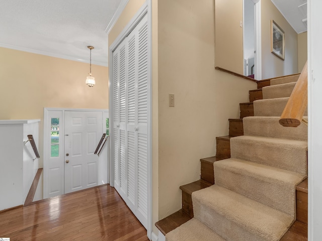 foyer entrance with hardwood / wood-style flooring and crown molding