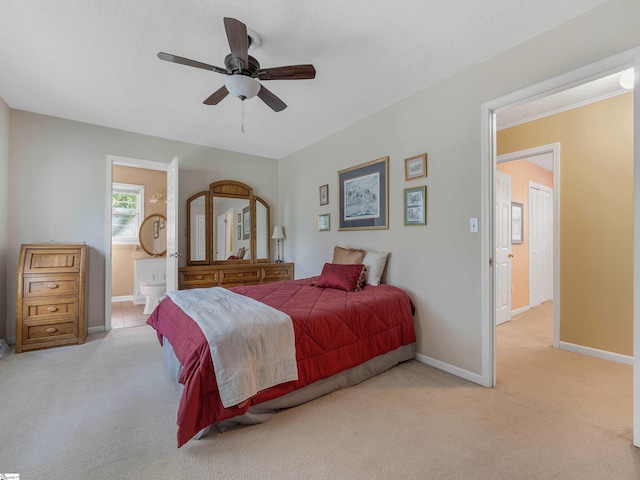 bedroom with a textured ceiling, ceiling fan, ensuite bathroom, and light carpet