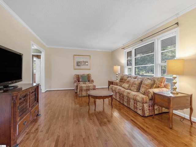 living room with light wood-type flooring, ornamental molding, and a textured ceiling