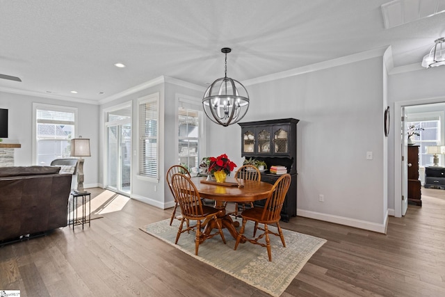 dining space featuring wood-type flooring, an inviting chandelier, and crown molding