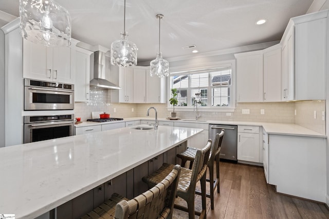 kitchen featuring stainless steel appliances, wall chimney range hood, sink, dark hardwood / wood-style floors, and white cabinetry