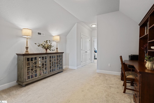 office with light carpet and vaulted ceiling