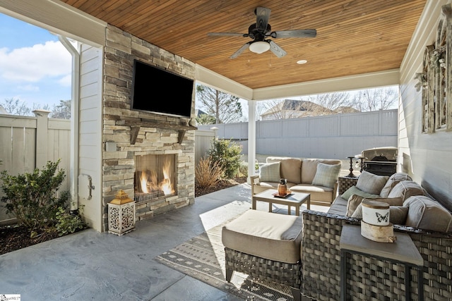 view of patio / terrace featuring an outdoor stone fireplace and ceiling fan