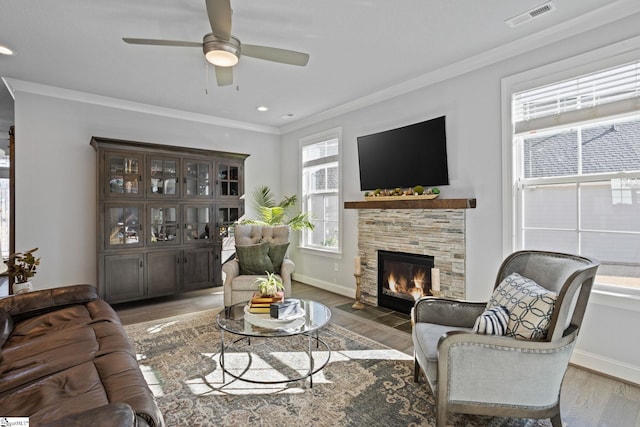 living room featuring a fireplace, a healthy amount of sunlight, dark hardwood / wood-style floors, and ornamental molding