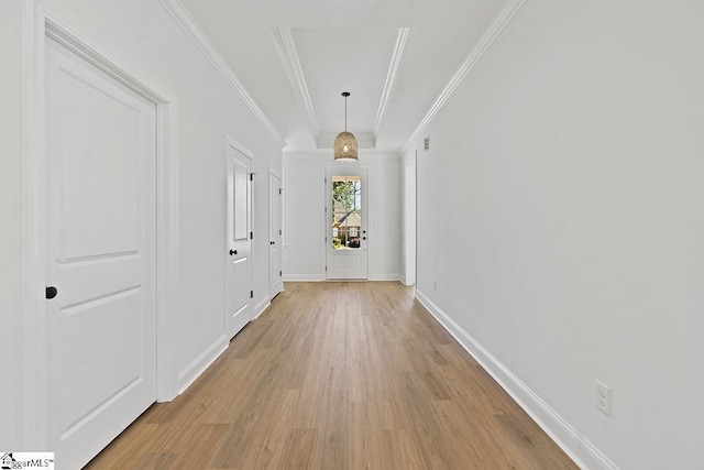 corridor with light hardwood / wood-style flooring and ornamental molding