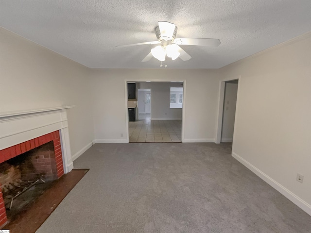 unfurnished living room with carpet flooring, a textured ceiling, a brick fireplace, and ceiling fan