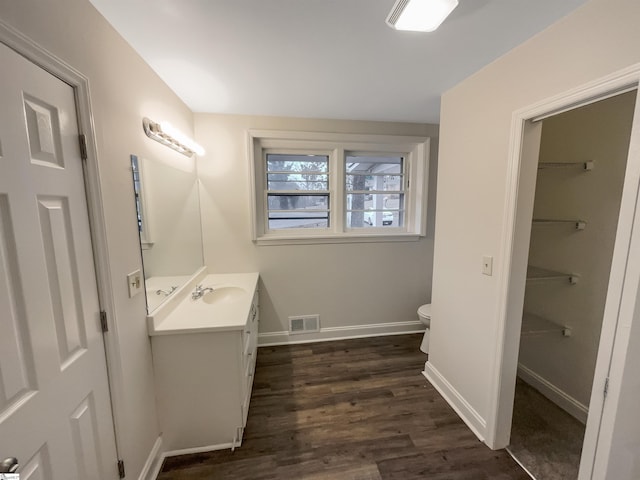 bathroom featuring hardwood / wood-style flooring, vanity, and toilet