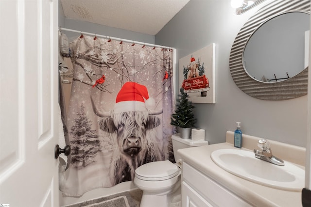 bathroom featuring vanity, toilet, and a textured ceiling