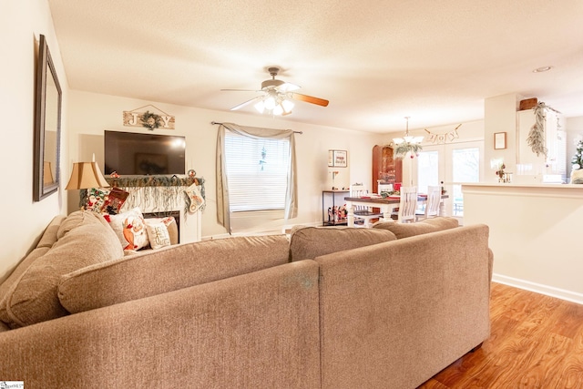 living room with wood-type flooring and ceiling fan with notable chandelier