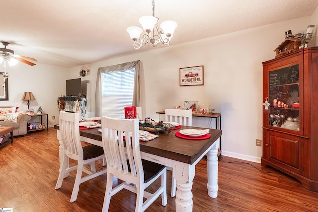 dining area with ceiling fan with notable chandelier and wood-type flooring