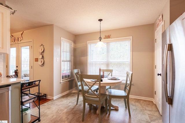 dining space featuring french doors and a textured ceiling