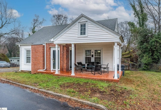 back of property with a porch and a lawn