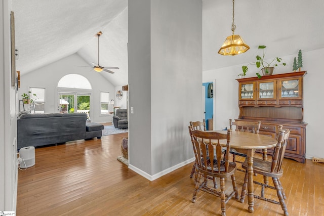 dining space with light wood-type flooring, ceiling fan, and lofted ceiling