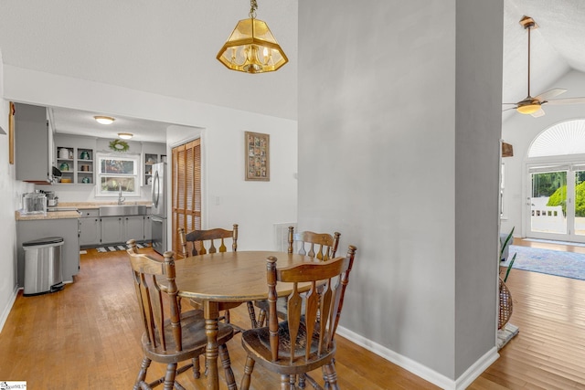 dining area featuring hardwood / wood-style flooring, ceiling fan, lofted ceiling, and sink