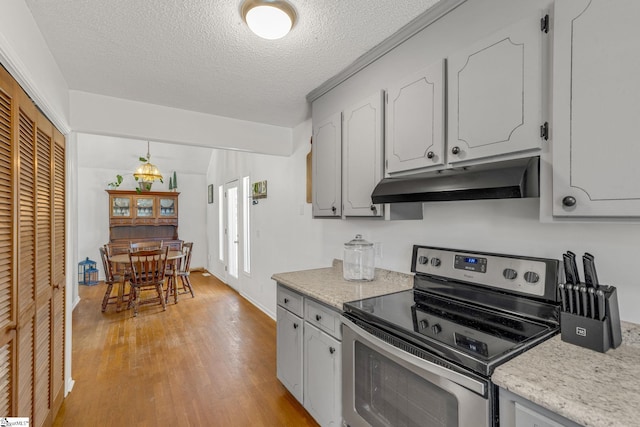 kitchen featuring white cabinets, a textured ceiling, light hardwood / wood-style floors, and stainless steel electric stove