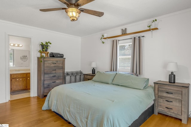 bedroom with light wood-type flooring, ensuite bath, ceiling fan, and crown molding