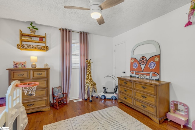 bedroom featuring wood-type flooring, a textured ceiling, and ceiling fan