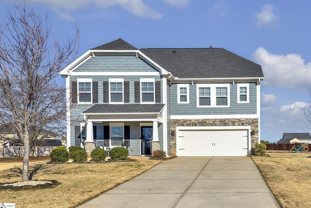 craftsman house with covered porch, a garage, and a front lawn