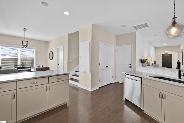 kitchen with stainless steel dishwasher, sink, hanging light fixtures, and dark wood-type flooring