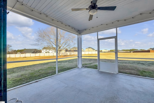 unfurnished sunroom featuring ceiling fan