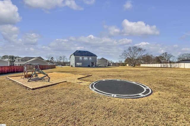 view of yard with a playground and a trampoline