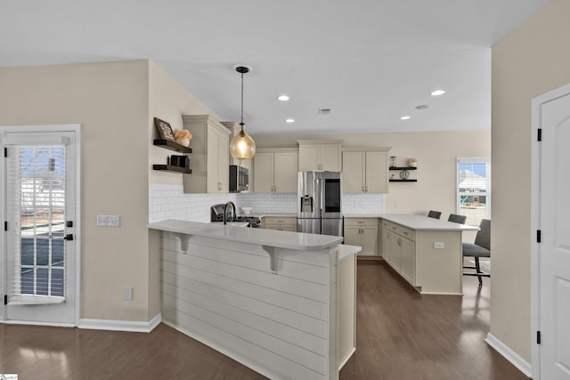 kitchen with a kitchen bar, kitchen peninsula, and appliances with stainless steel finishes