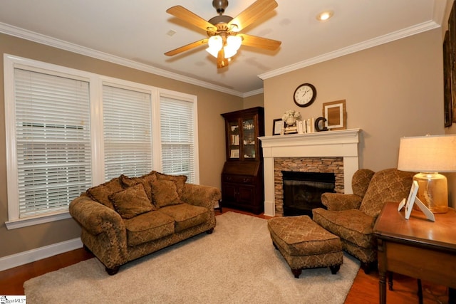 living room with hardwood / wood-style flooring, ceiling fan, a stone fireplace, and ornamental molding