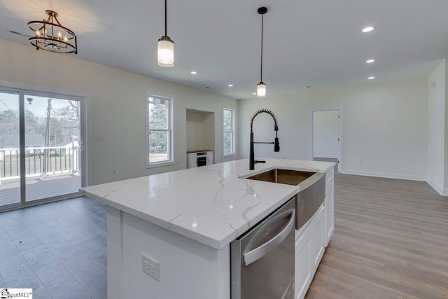 kitchen with white cabinets, stainless steel dishwasher, pendant lighting, a sink, and recessed lighting