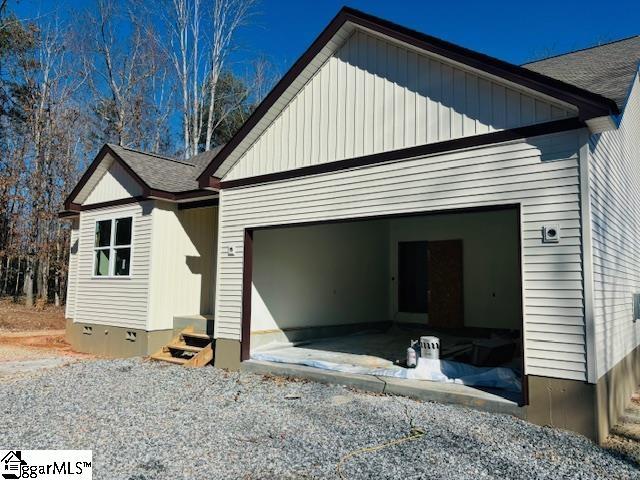 view of home's exterior featuring board and batten siding, entry steps, crawl space, and an attached garage