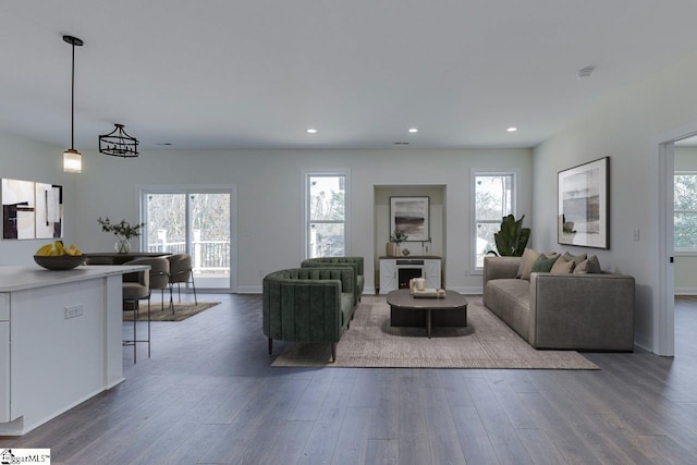 living area featuring dark wood-style floors, recessed lighting, baseboards, and a healthy amount of sunlight