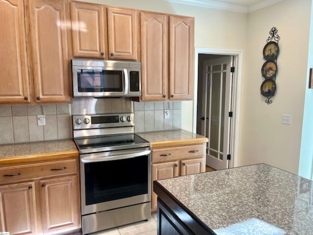 kitchen with stainless steel appliances, tasteful backsplash, crown molding, and light tile patterned flooring