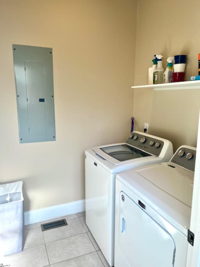 laundry room featuring light tile patterned floors, washing machine and dryer, and electric panel