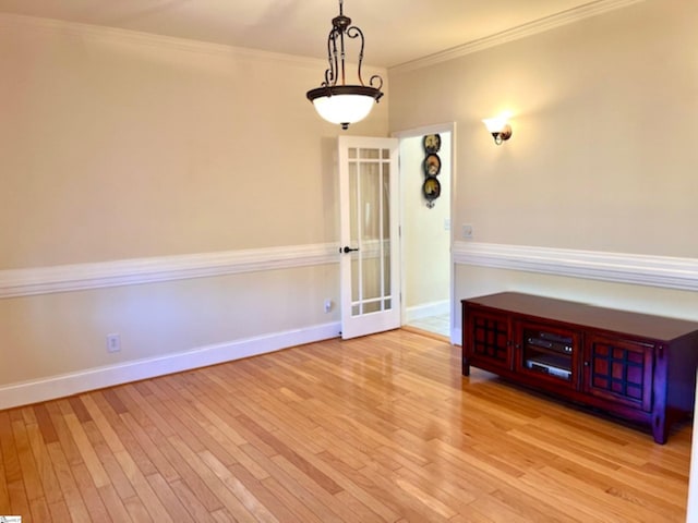 unfurnished room with french doors, light hardwood / wood-style floors, and ornamental molding