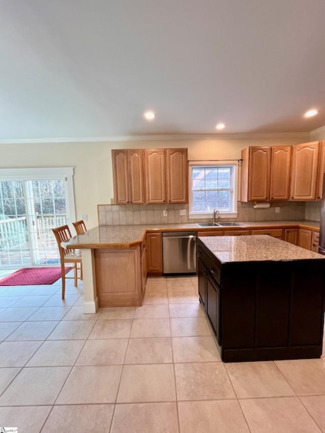 kitchen featuring stainless steel dishwasher, plenty of natural light, light tile patterned flooring, and sink