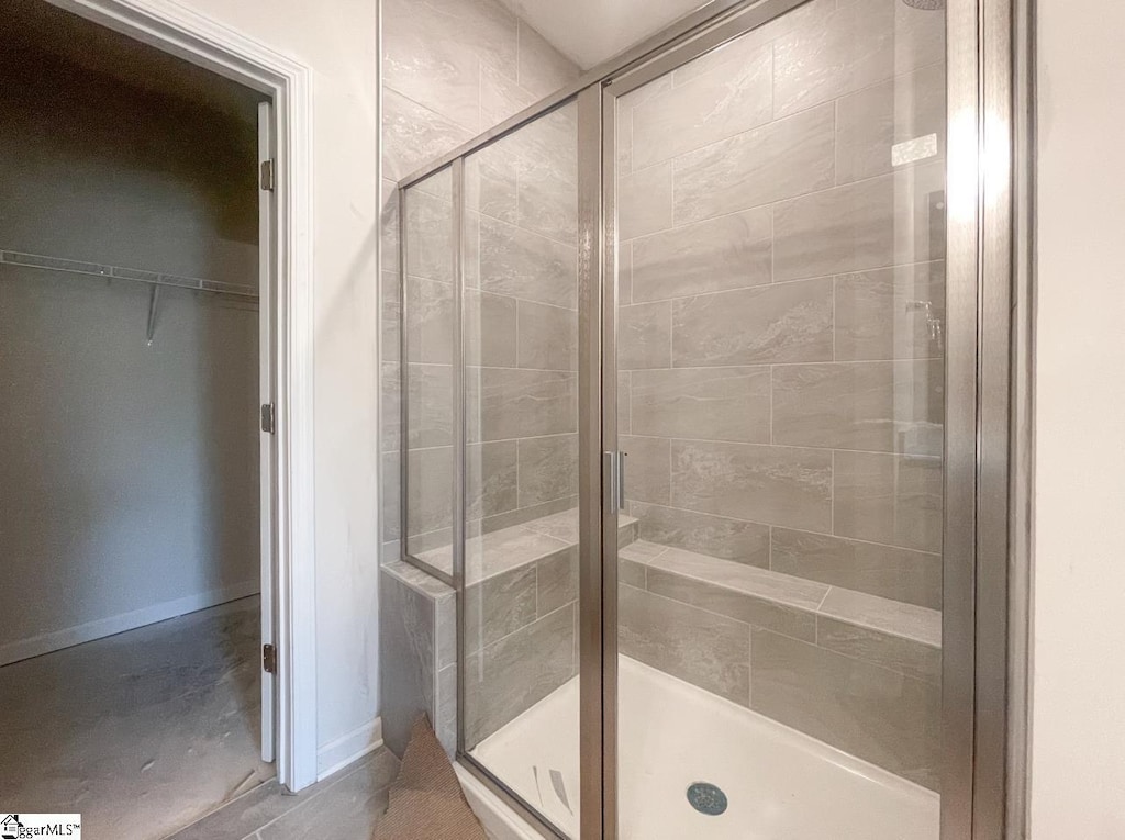 bathroom featuring a shower stall and baseboards