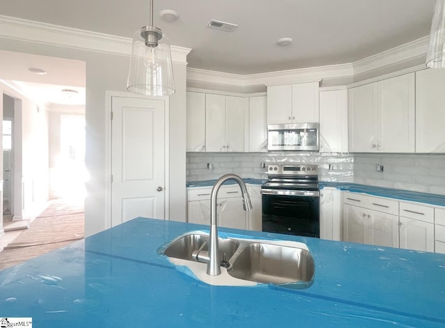 kitchen featuring a sink, white cabinetry, appliances with stainless steel finishes, decorative backsplash, and crown molding