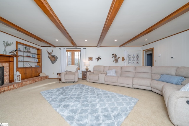 carpeted living room featuring beamed ceiling, ornamental molding, and a fireplace