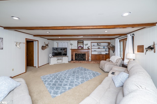 carpeted living room featuring beamed ceiling, wood walls, and a fireplace