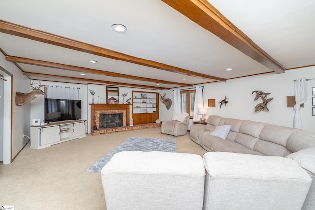 living room featuring a fireplace, beam ceiling, and light carpet