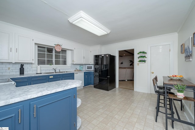 kitchen featuring blue cabinetry, sink, white appliances, decorative backsplash, and white cabinets