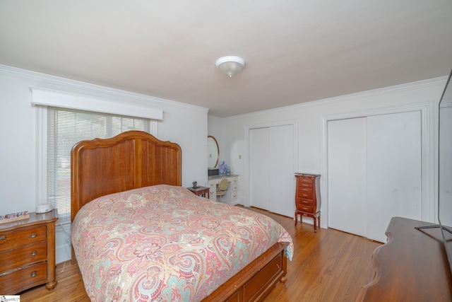 bedroom with multiple closets, ornamental molding, and light wood-type flooring