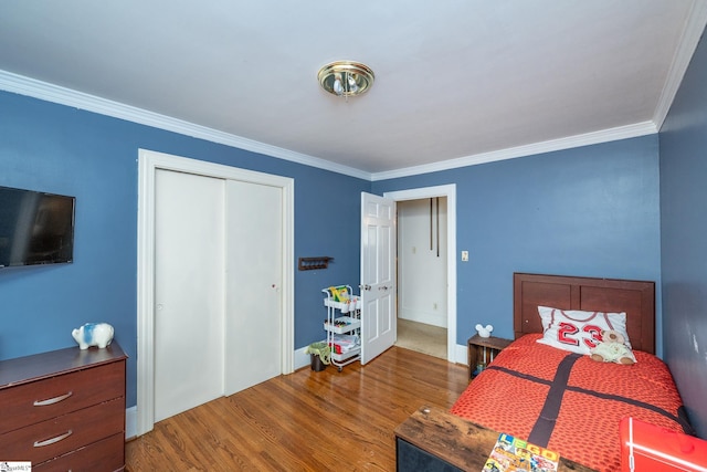 bedroom featuring a closet, hardwood / wood-style floors, and crown molding